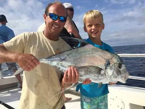 Captain and young angler holding an African pompano