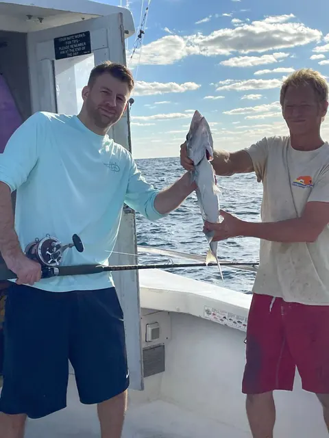 Friends celebrating a catch together on a party boat charter in St. Augustine, FL