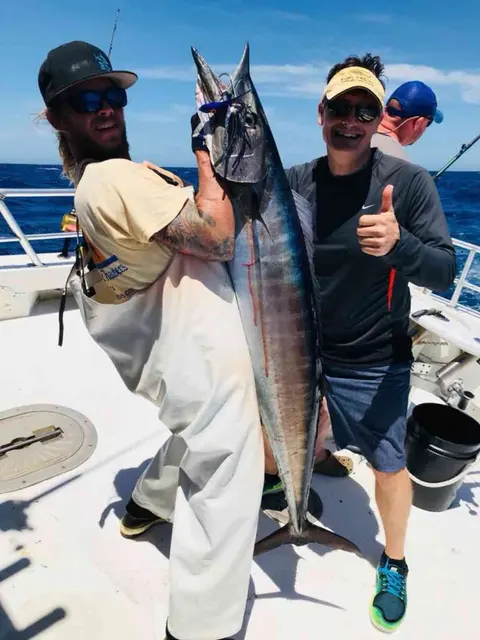 Two anglers celebrating a wahoo caught offshore near Ponte Vedra Beach, FL