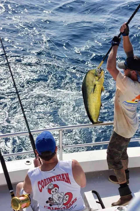 Angler bringing a mahi-mahi aboard on an offshore trip near Butler Beach, FL